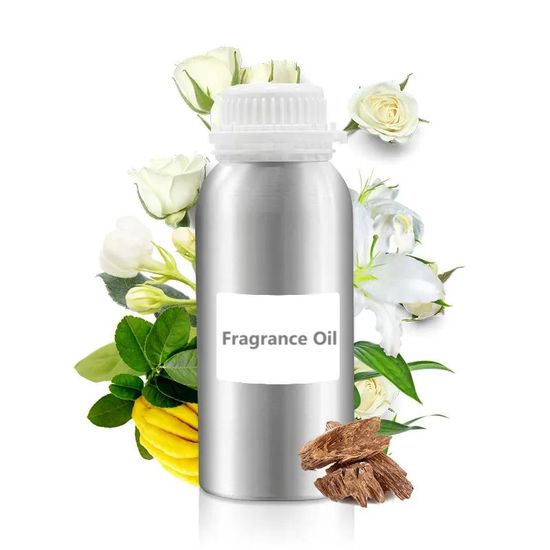 Large aluminum bottle of fragrance oil surrounded by white roses, green leaves, and raw wood chips